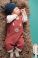Schlafender Junge trägt bordeaux rote Lama Baby Latzhose mit Brusttasche Lama mit Ohren, kontraststarken Holz Knöpfe & Beinumschlag - weißer langarm Wickelbody Lama - graue babysöckchen - dunkelblaue Zipfelmütze mit Happy Lama von Pinokio - Babyphoto