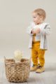 Stehender Junge trägt beige Kapuzen Plüschjacke Flausch - Weißen Baby Langarmbody mit Papagei Motiv - Currygelbe Babyhose mit Knöpfe & breitem Komfortbund von Pinokio - Kinderphoto