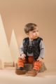 Baby Junge trägt grauen Wickelbody mit Bär - Braun orangene Pumphose mit Patch BEAR´S CLUB - Schwarze kurze Steppweste von Pinokio - Babyphoto Kinderphoto