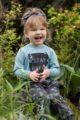 Lachendes Mädchen trägt Baby Kinder türkis grünes Langarm Shirt STAY GREEN Statement - Braunes Stirnband & Pumphose mit Zweige & Blätter Muster mit Kordel von Pinokio - Babyphoto Kinderphoto