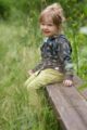 Lachendes Mädchen trägt Kinder Baby grüne Pumphose Haremshose mit Tasche STAY GREEN Print - Braunen Kapuzenpullover mit türkisen Zweige Blätter von Pinokio - Babyphoto Kinderphoto