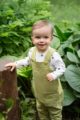 Junge trägt grüne Baby Latzhose mit Tasche & STAY GREEN Print Statement - Weißes Oberteil langarm mit Sterne von Pinokio - Babyphoto Kinderphoto