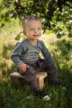 Sitzender Junge trägt blau-grünen Babybody langarm mit Auto - Pumphose mit Taschen, Komfortbund & Bündchen in Grau Braun von Pinokio - Babyphoto Kinderphoto