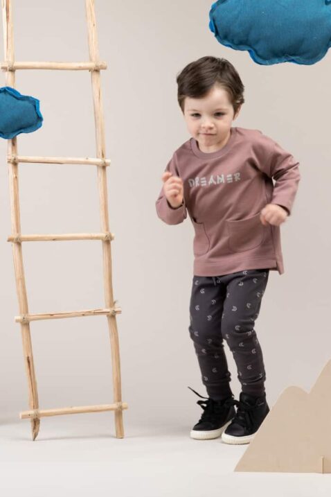 Baby Junge trägt beiges Sweatshirt Pullover mit Taschen & DREAMER Print - Leggings Sweathose dunkelgrau mit Halbmonden All-Over Muster aus Baumwolle von Pinokio - Babyphoto Kinderphoto laufender Junge