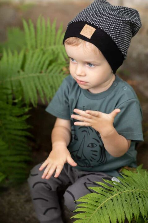 Kinder Baby Mütze schwarz-weiß gestrickt mit Bommel und Tiger-Patch + Kinder T-shirt mit Tigerkopf-Druck in Dunkelgrün + Baby Sweathose mit Streifen und Kordel in Dunkelgrau von PINOKIO - Inspiration Kinderfoto
