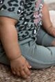 Sitzendes Baby Kind Mädchen mit grüner Jogginghose mit Taschen, Flechtmustern, Zierkordel, Bündchen & JUNGLE Print Basic Jogger von DIRKJE - Babyfoto Detailfoto