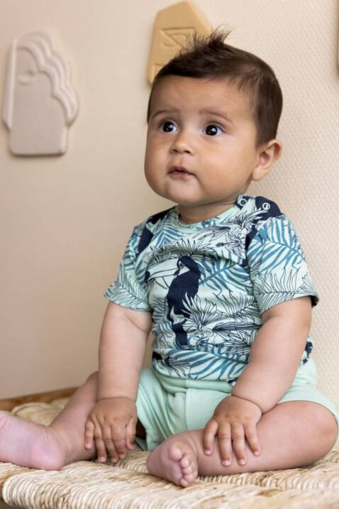 Jungenshorts für Babys mit Patch VIBES, Taschen, Kordel & gestreiften Bündchen in Grün für den Sommer von DIRKJE - Babyfoto sitzendes Kind