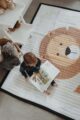 Weich gepolsterte & gesteppte Spielmatte Spieldecke für Kinder & Babys mit großer Spielfläche 150x200 cm & Löwen Tiermotiv von Love by Lily - Draufsicht Kind beim Lesen Kinderzimmer