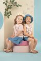 Baby & Kinder Rock Denim Blue, T-Shirt mit Erdbeeren hellrosa, Top mit Blüten & Blumen weiß rosa - Shorts blau von Pinokio - Kinderfoto zwei lachende Mädchen