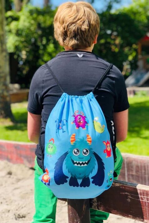Blauer umweltfreundlicher, nachhaltiger Gymnastikbeutel Schulsportbeutel für Kinder & Kleinkinder mit verstellbaren Tragekordeln & Monster Motiven von HECKBO - Kinderfoto Junge trägt eine hochwertige XL Turnbeutel Jungentasche