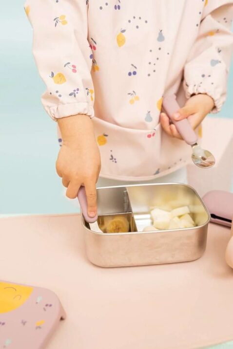 Langarm-Lätzchen für Babys & Kleinkinder mit Auffangtasche & Zitronen, Kirschen & Birnen gemustert in Hellrosa von THE COTTON CLOUD - Kinderforto Mädchen in der Küche trägt wasserdichtes Baby Lätzchen mit langen Ärmeln & Früchte Motive