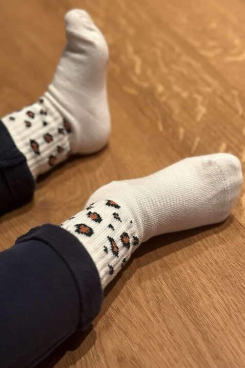 Mädchen trägt beige Tenissocken mit Leo-Muster & geripptem Schaft für Babys & Kinder aus einer elastischen Baumwollmischung von J.CLAY Socks - Nahaufnahme des Fußes mit hochwertigen Premiumsocken, gefertigt in Portugal