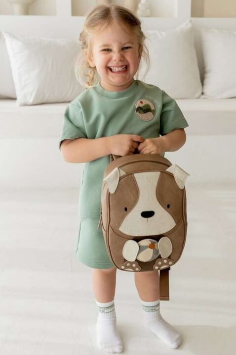 Großer XXL Baby & Kinder Mädchenrucksack Hund Henri aus veganem, recyceltem Leder in Vintage Braun Retro von LITTLE WHO - Kinderfoto lachendes blondes Mädchen trägt Hunde Kindergartenrucksack mit Tragegriff & gepolsterten Schulterriemen