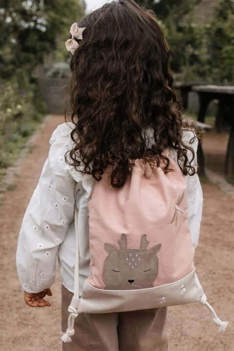 Hochwertiger Kinderbeutel Freizeitbeutel mit recyceltem Futter, Lederimitat Kunstleder & Baumwolle von LITTLE WHO - Kinderfoto Mädchen trägt Kinder Schulbeutel Rucksackbeutel mit REH JANNE Tiermotiv in Hellrosa & weiße festliche Bluse